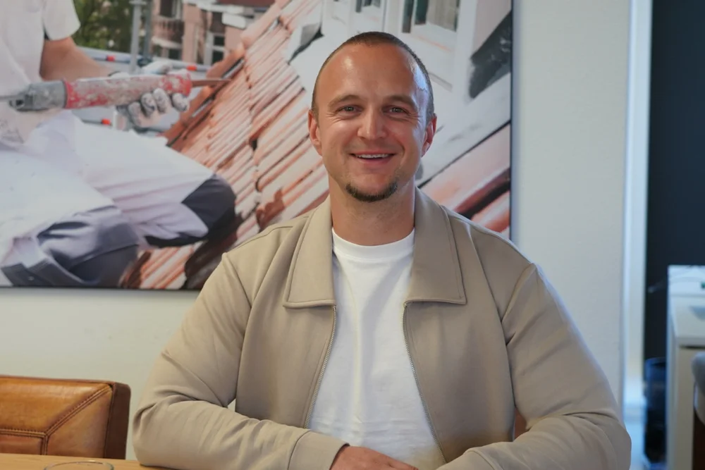 Mike Fecken aan tafel op kantoor, met laptop en notitieblok voor zich